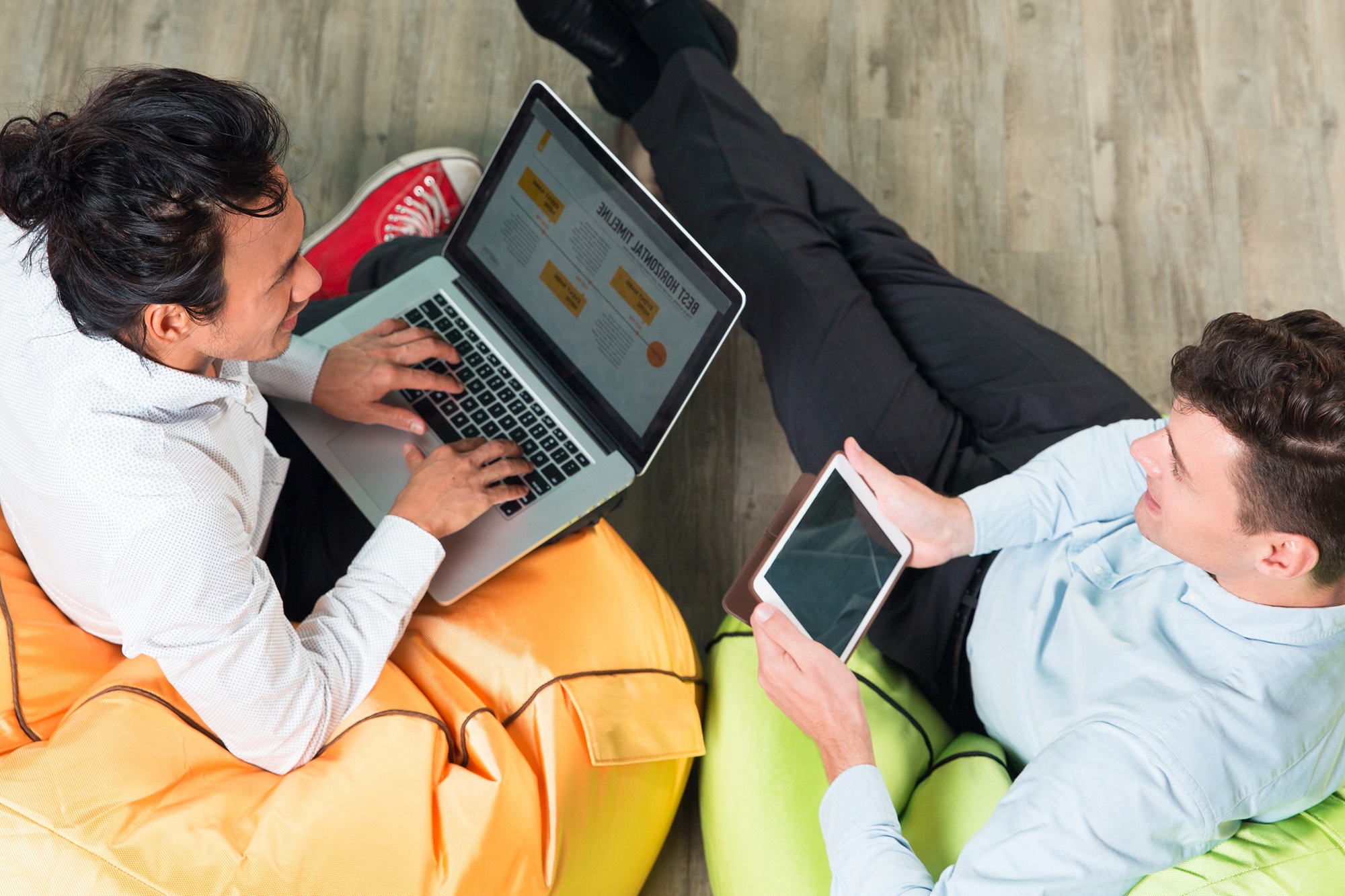 Business team collaborating on tablet and laptop